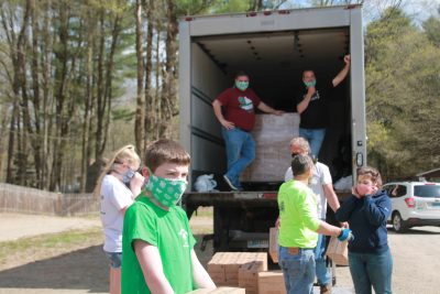 youth unloading cases of milk with adult 4-H volunteers